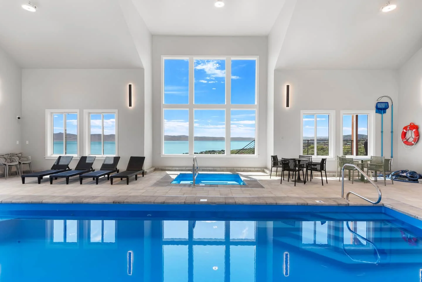 Indoor pool and hot tub with tall windows overlooking Bear Lake