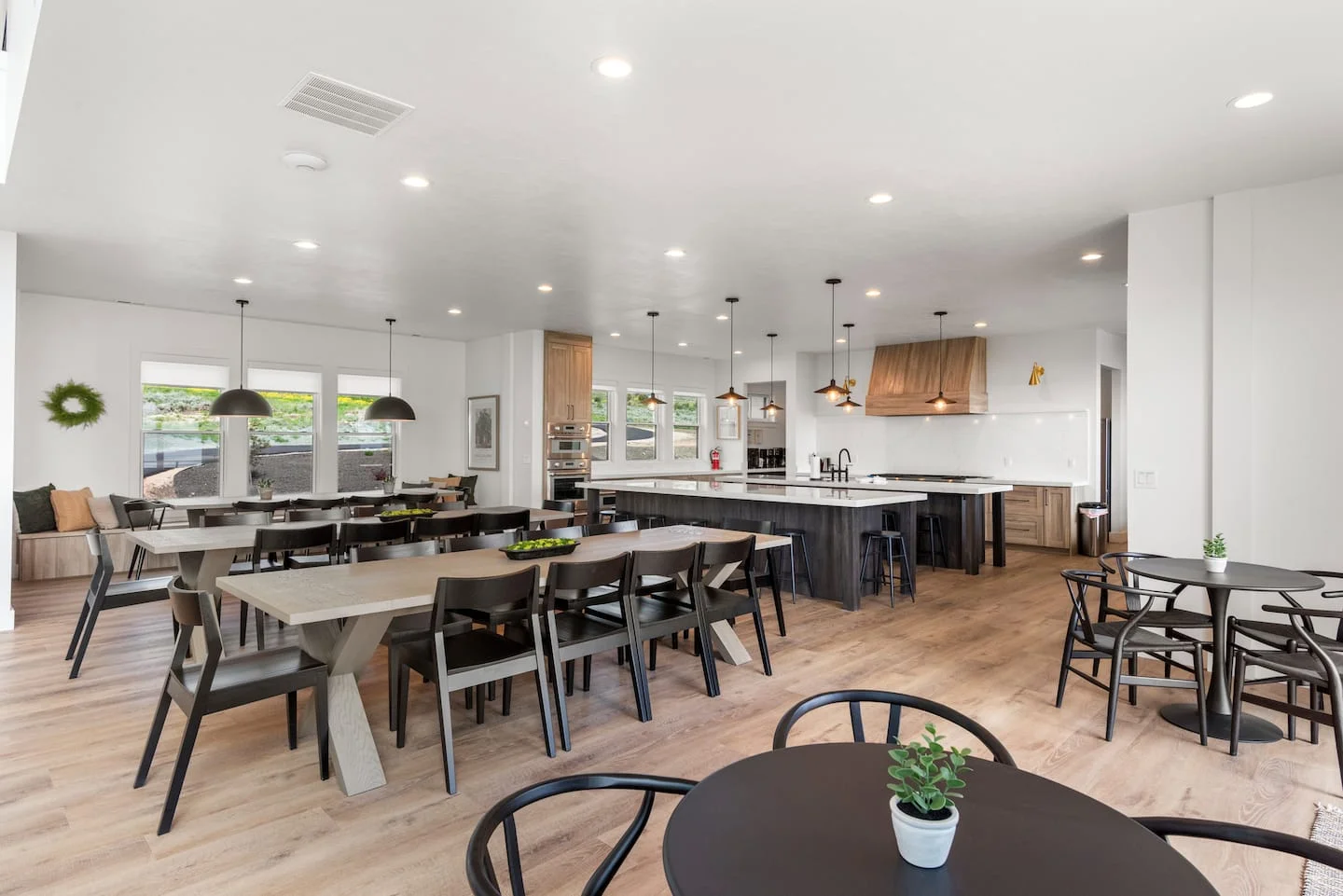 Large kitchen and dining area with long tables and natural wood finishes