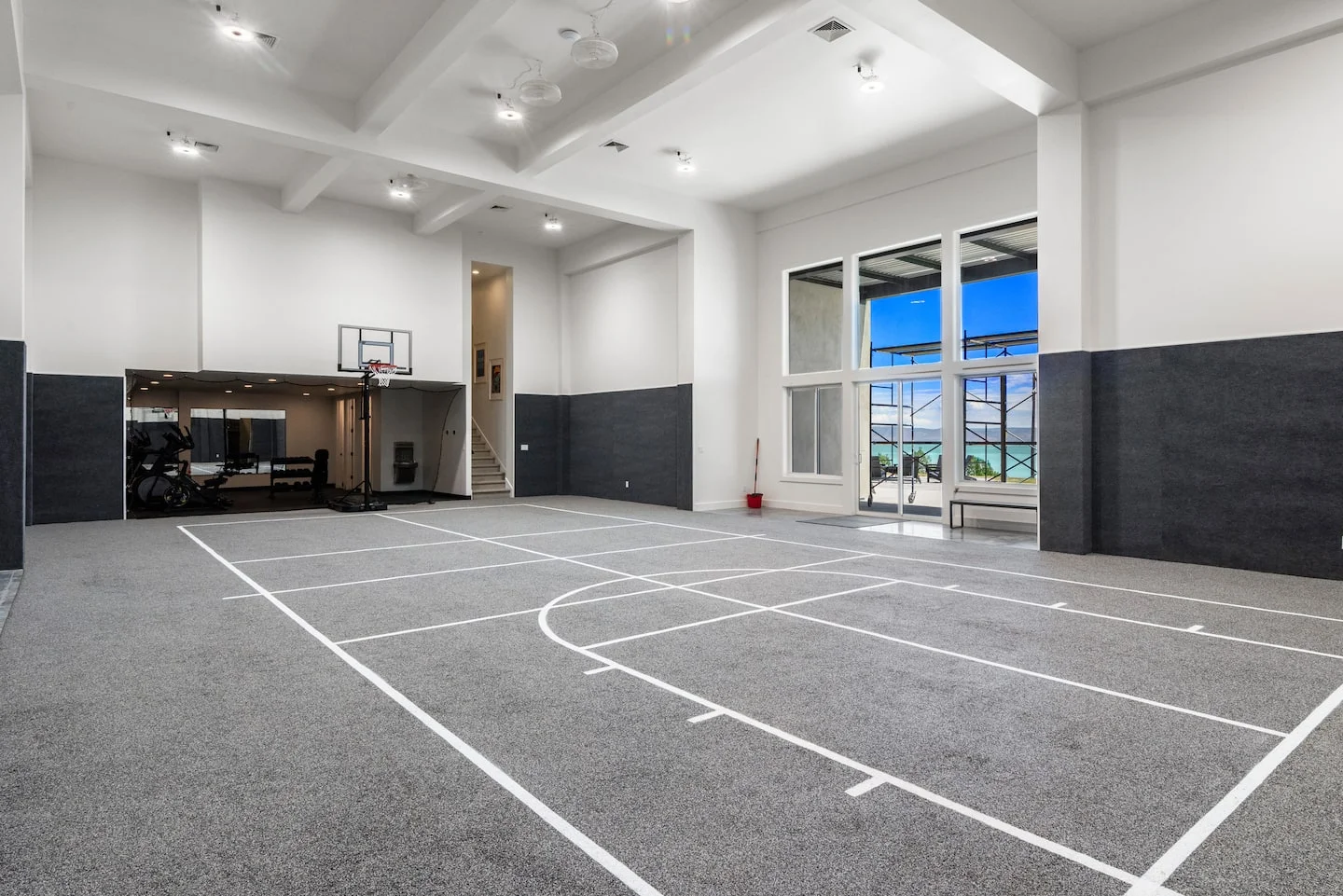 Private indoor basketball and pickleball court with tall windows